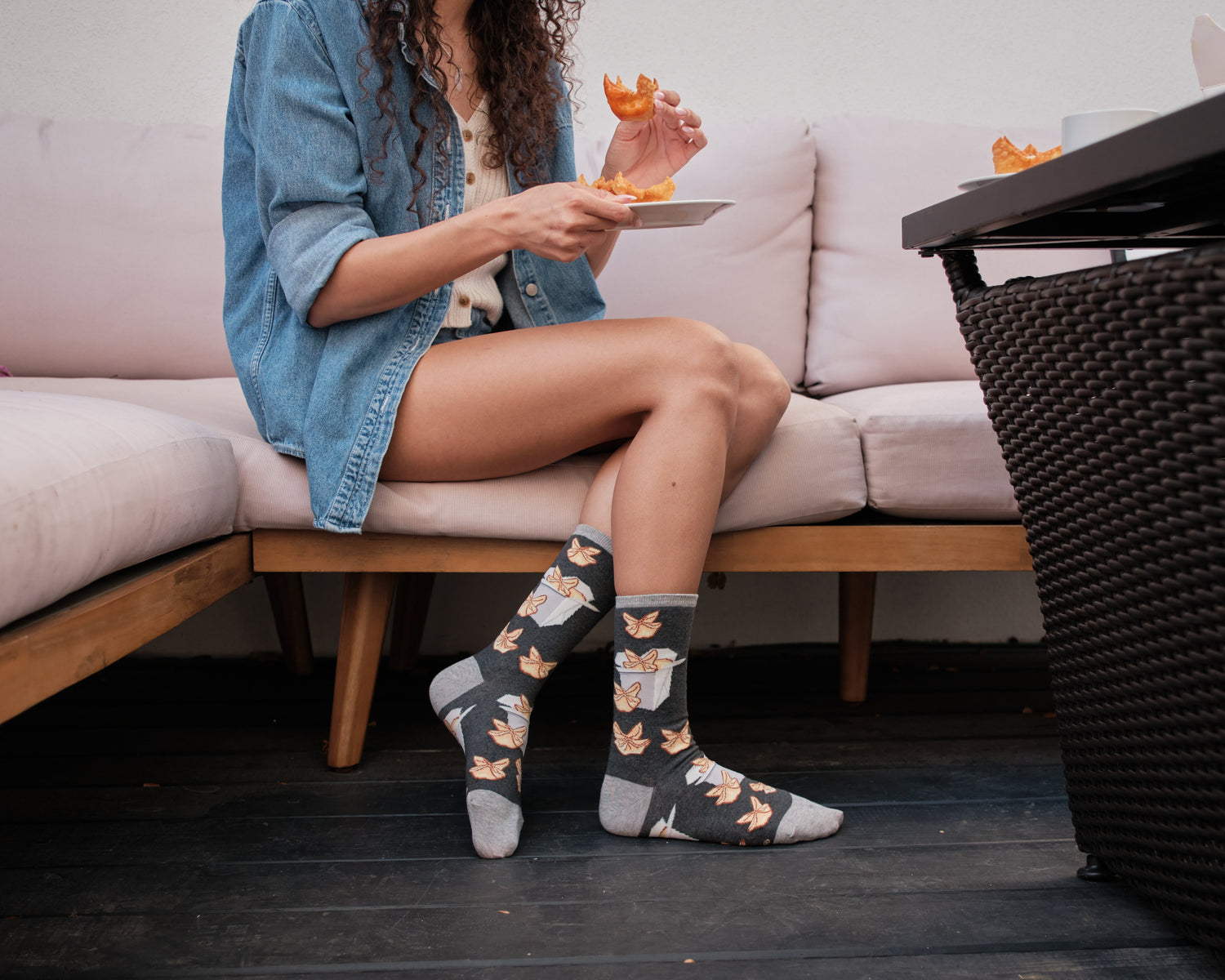 a woman eating crab rangoon while wearing crab rangoon themed socks