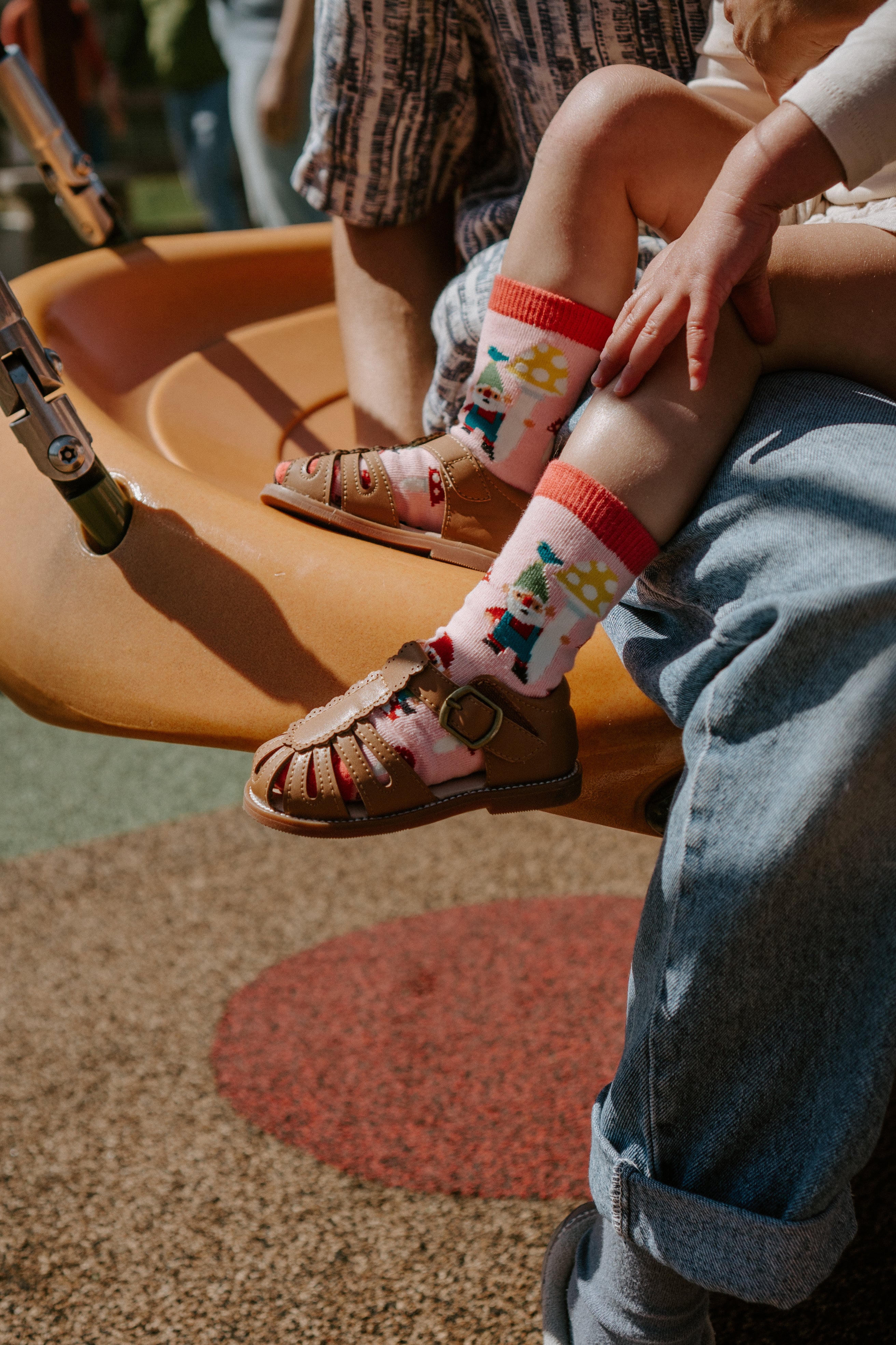 "photo of child wearing gnome garden kid's socks at park"