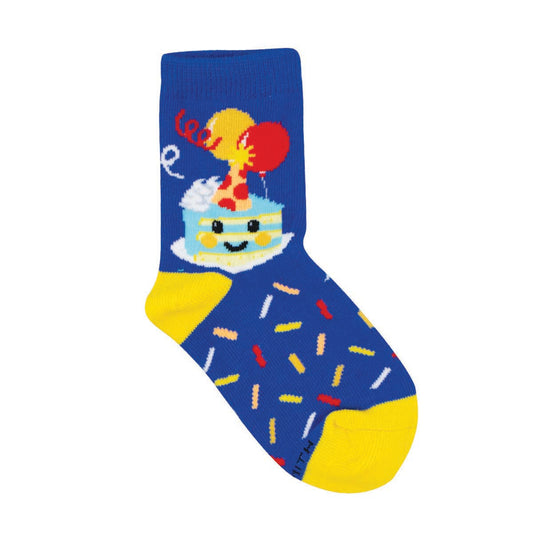 A pair of blue cotton crew socks with a novelty design of a smiling birthday cake with sprinkles and a party hat, intended for kids.