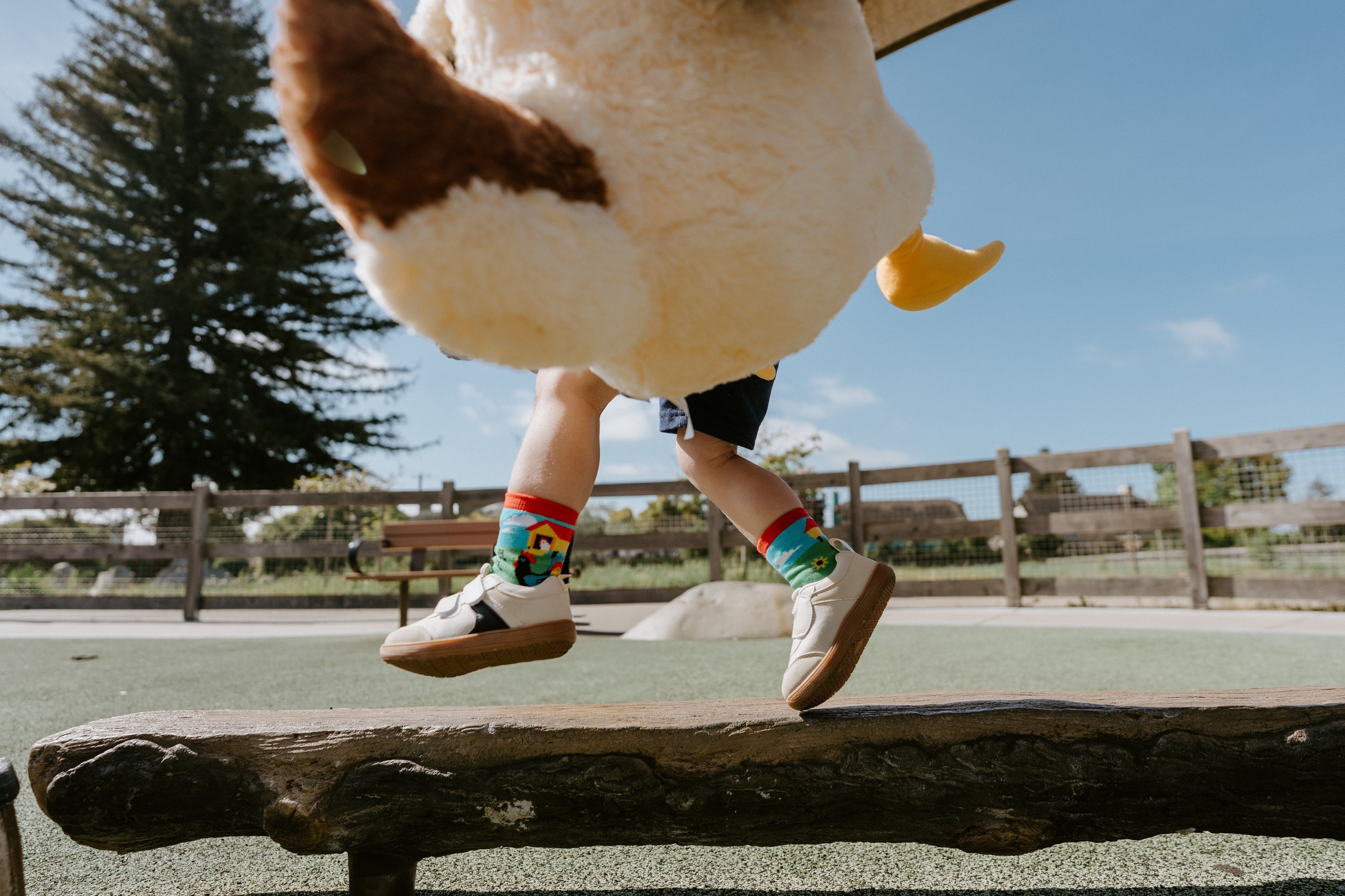 "child model skipping across bench wearing mo chickens kid's socks"