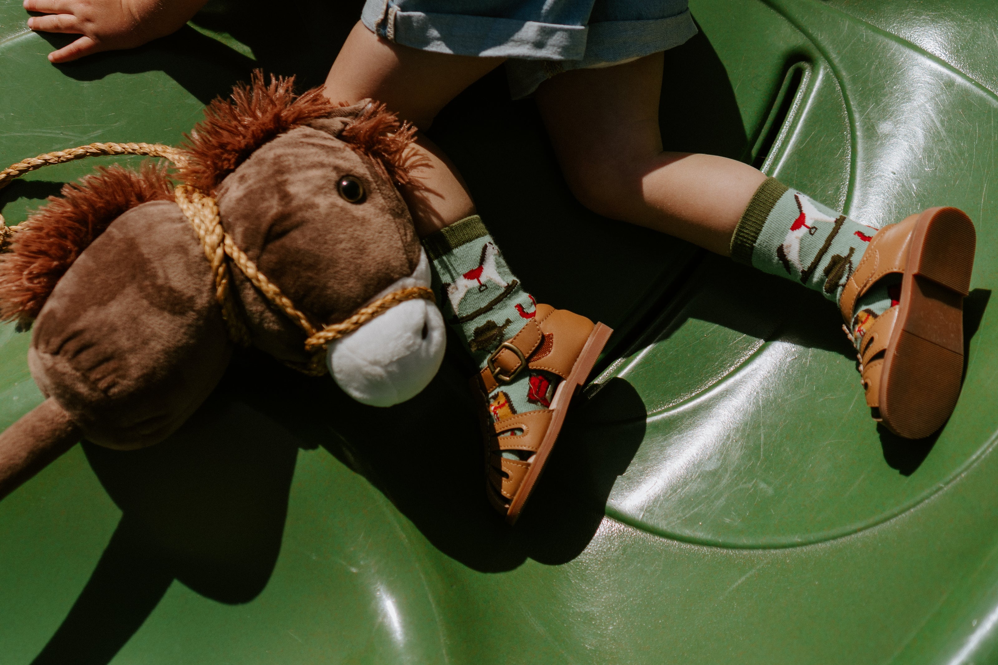 "child model wearing pony up kids socks with horse toy"