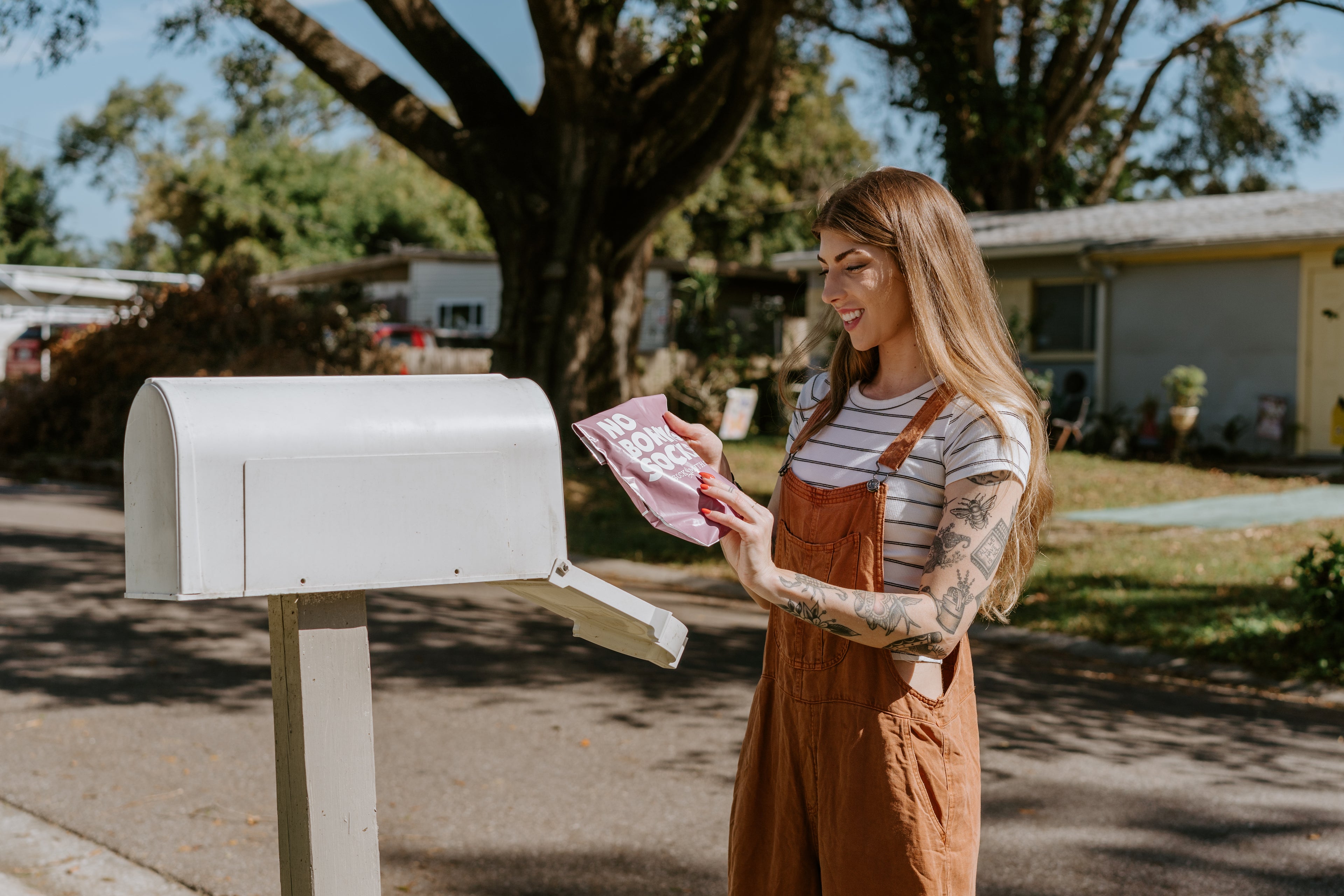 "woman retrieving package from mailbox"